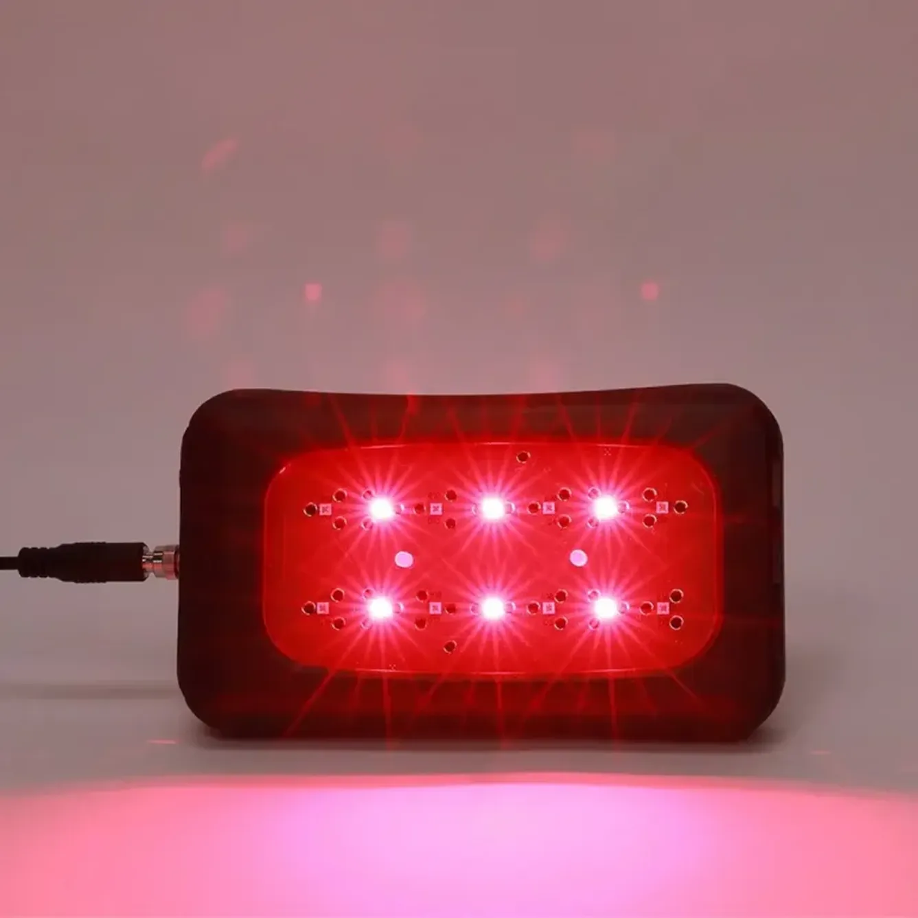 a front view of a LZR UltraBright device turned on, emitting red shining light.