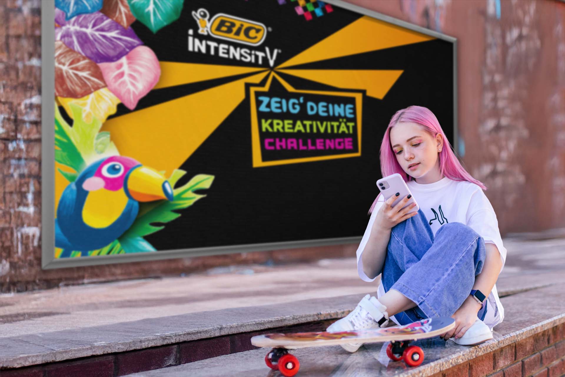 Eine junge Frau mit pinkfarbenen Haaren vor einem Werbeplakat der BIC Intensity 'Zeig' deine Kreativität Challenge'.