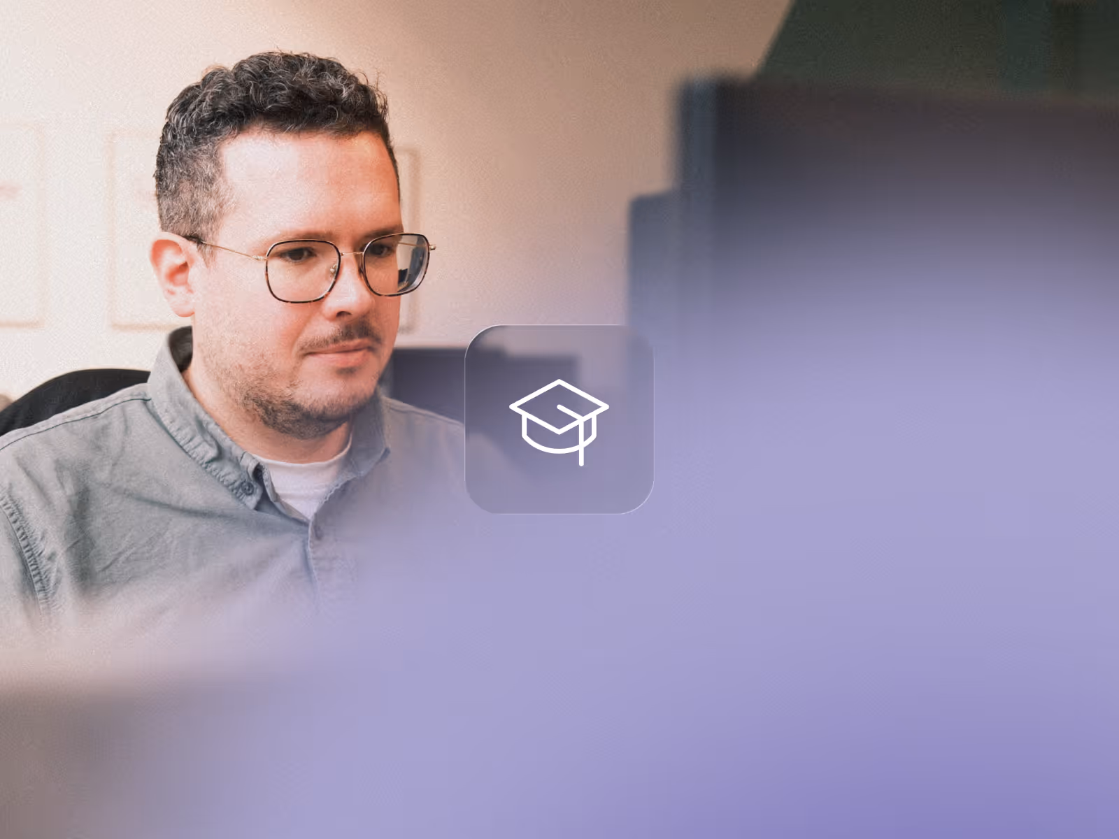 Ein Mann mit Brille und kurzem lockigem Haar arbeitet konzentriert an einem Computerbildschirm.