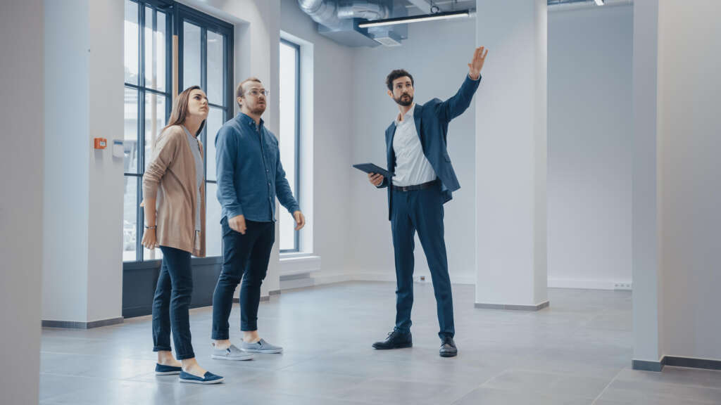 Real Estate Agent Showing a New Empty Office Space to Young professionals interested in dental real estate in florida