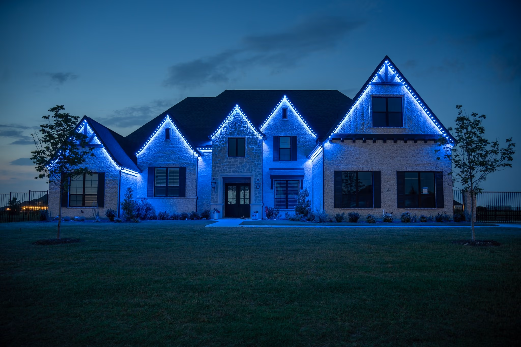 Color-changing permanent outdoor lighting displaying team colors on a house