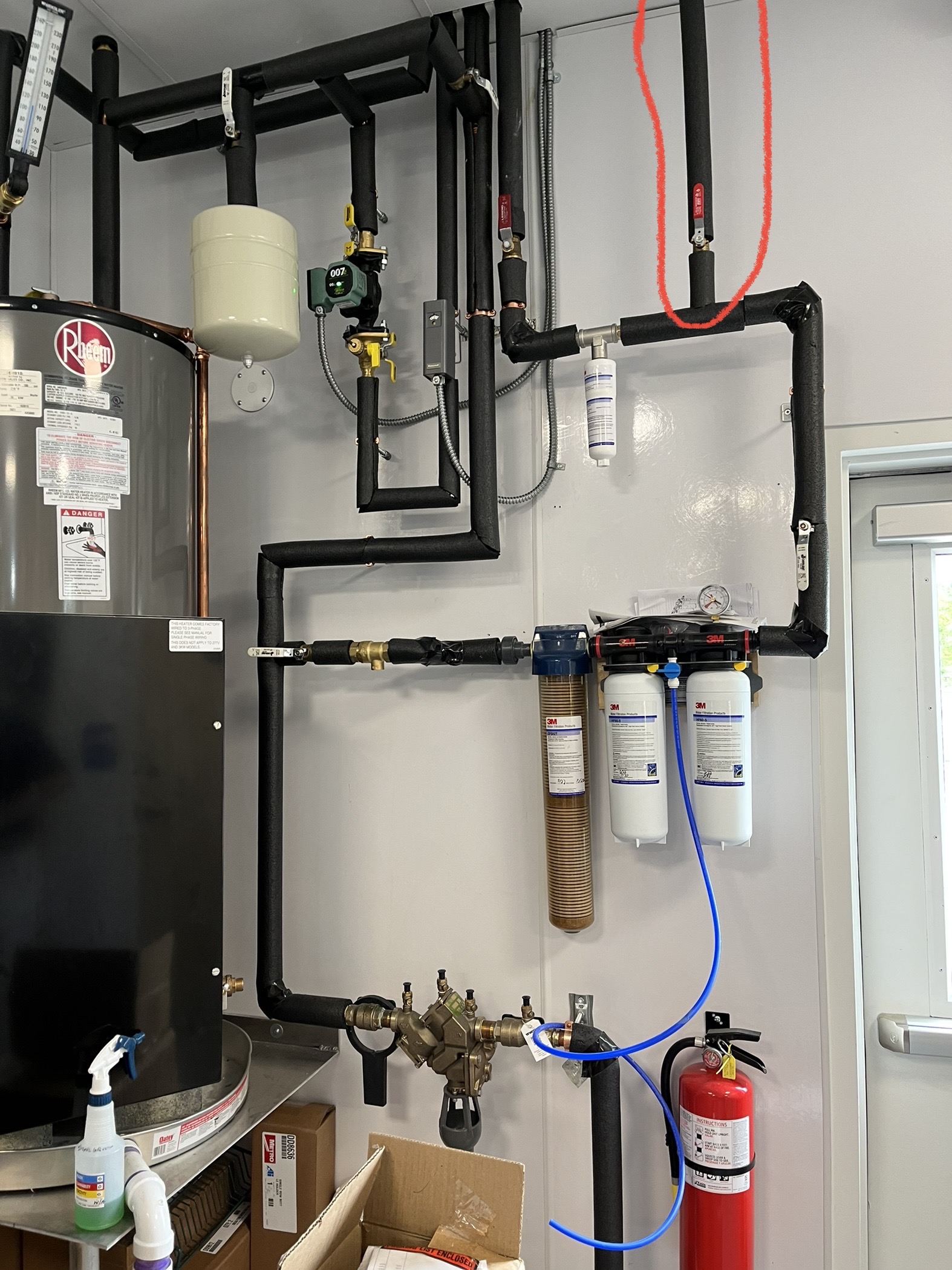 A professionally maintained mechanical room featuring a water heater and filtration system