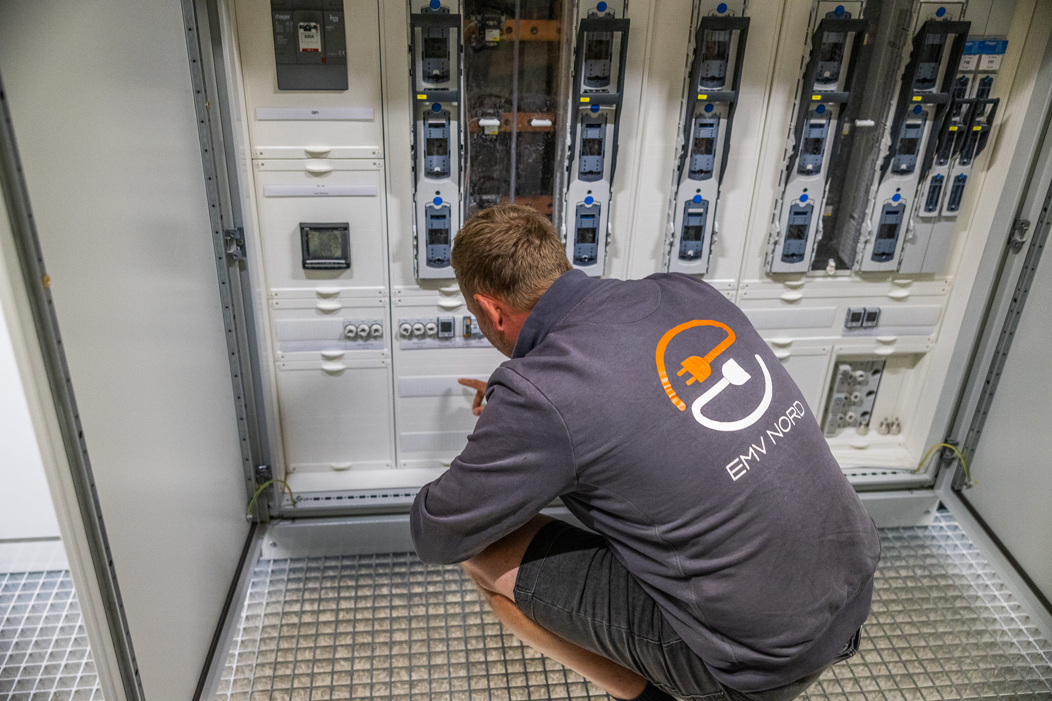 Ein Techniker mit EMV NORD Jacke arbeitet an einem elektrischen Schaltschrank.