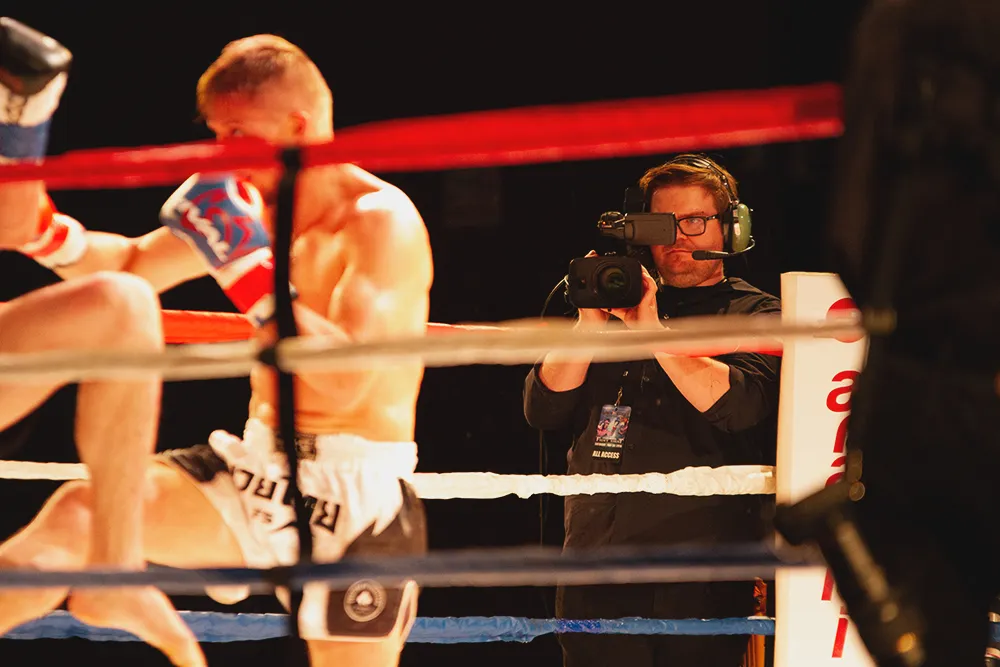 a camera man gets into the action next to the boxing ring