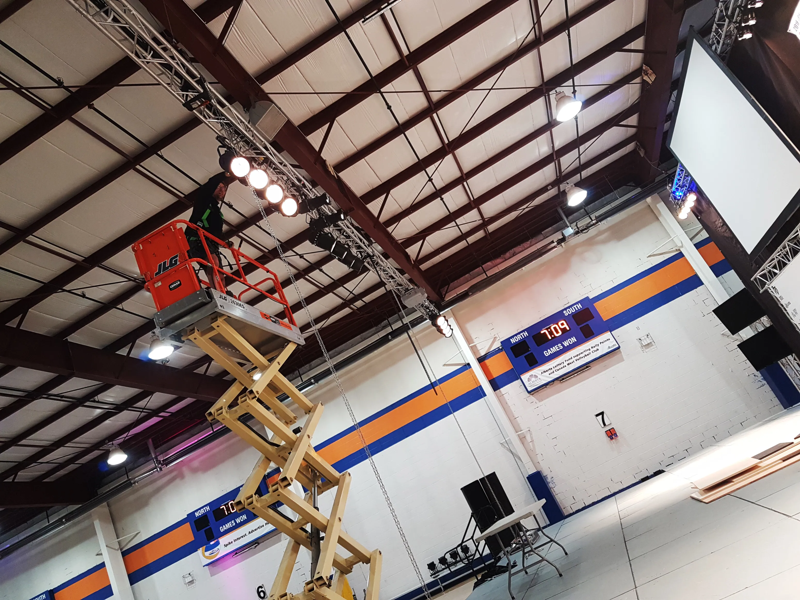 a lift raises a man into the ceiling to install lights for the event