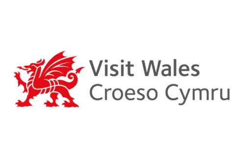 Red Welsh dragon symbol next to the text 'Visit Wales Croeso Cymru' in gray.