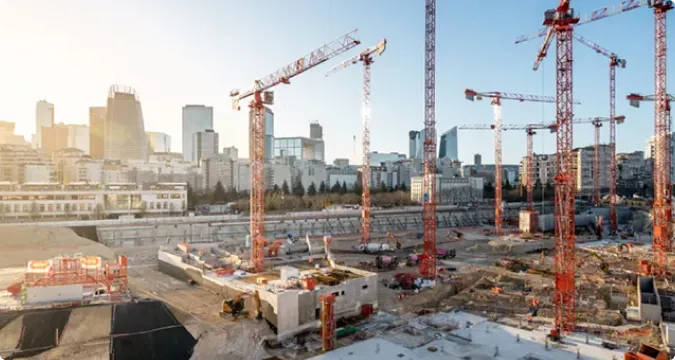 Grand chantier à grues devant les tours d'un quartier d'affaires