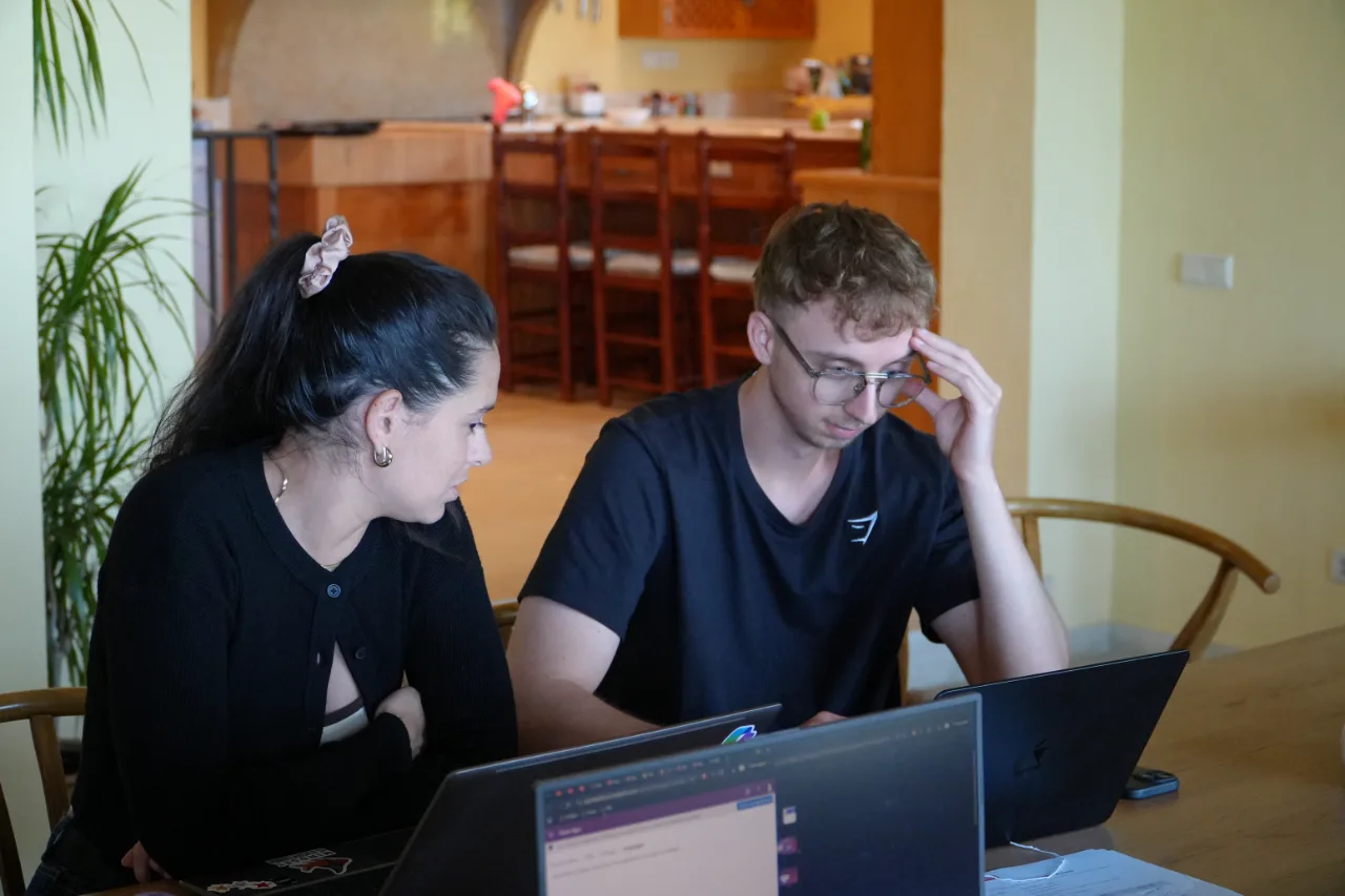 Deux membres de l'équipe YoungData travaillent côte à côte sur leurs ordinateurs, au séminaire de septembre 2026.