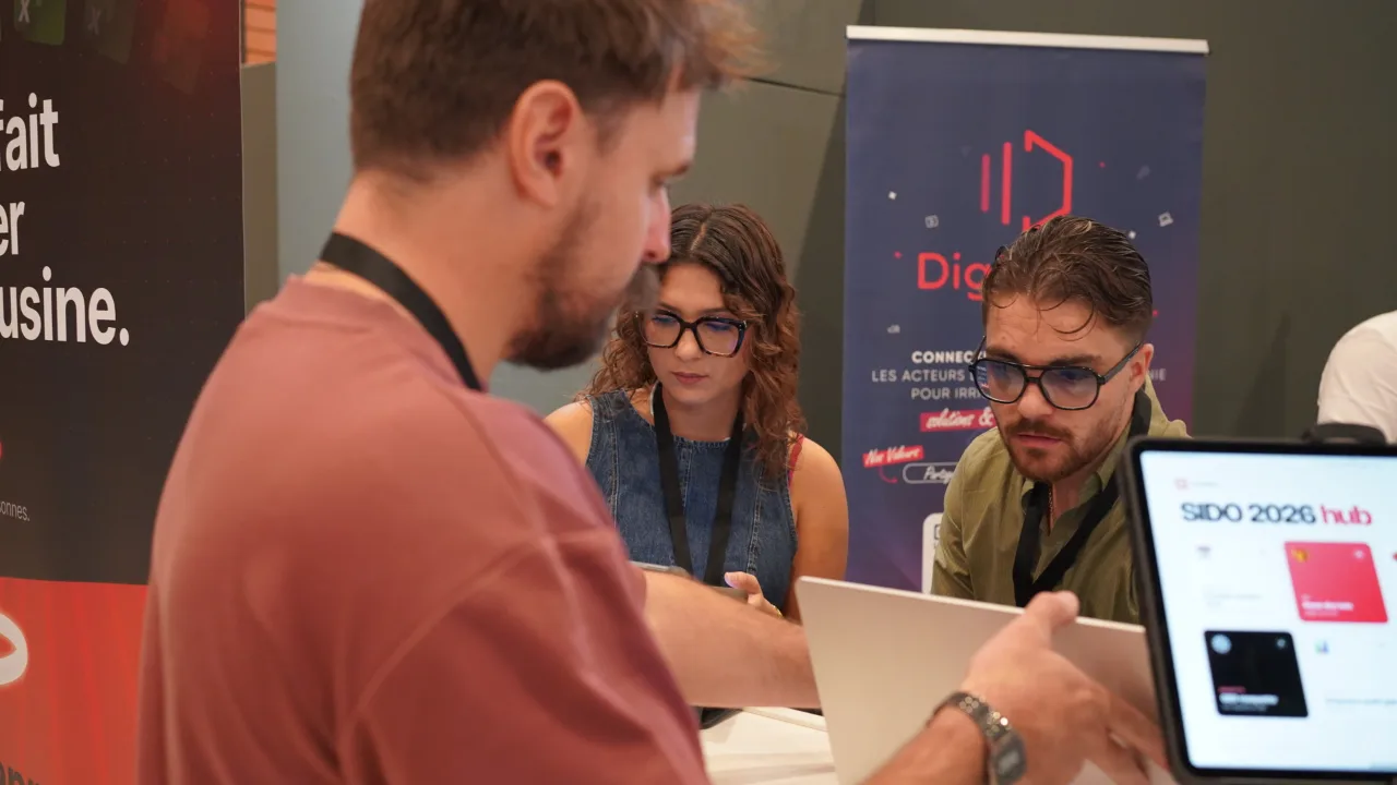 Échange autour d'une tablette sur un stand du salon SIDO 2026.