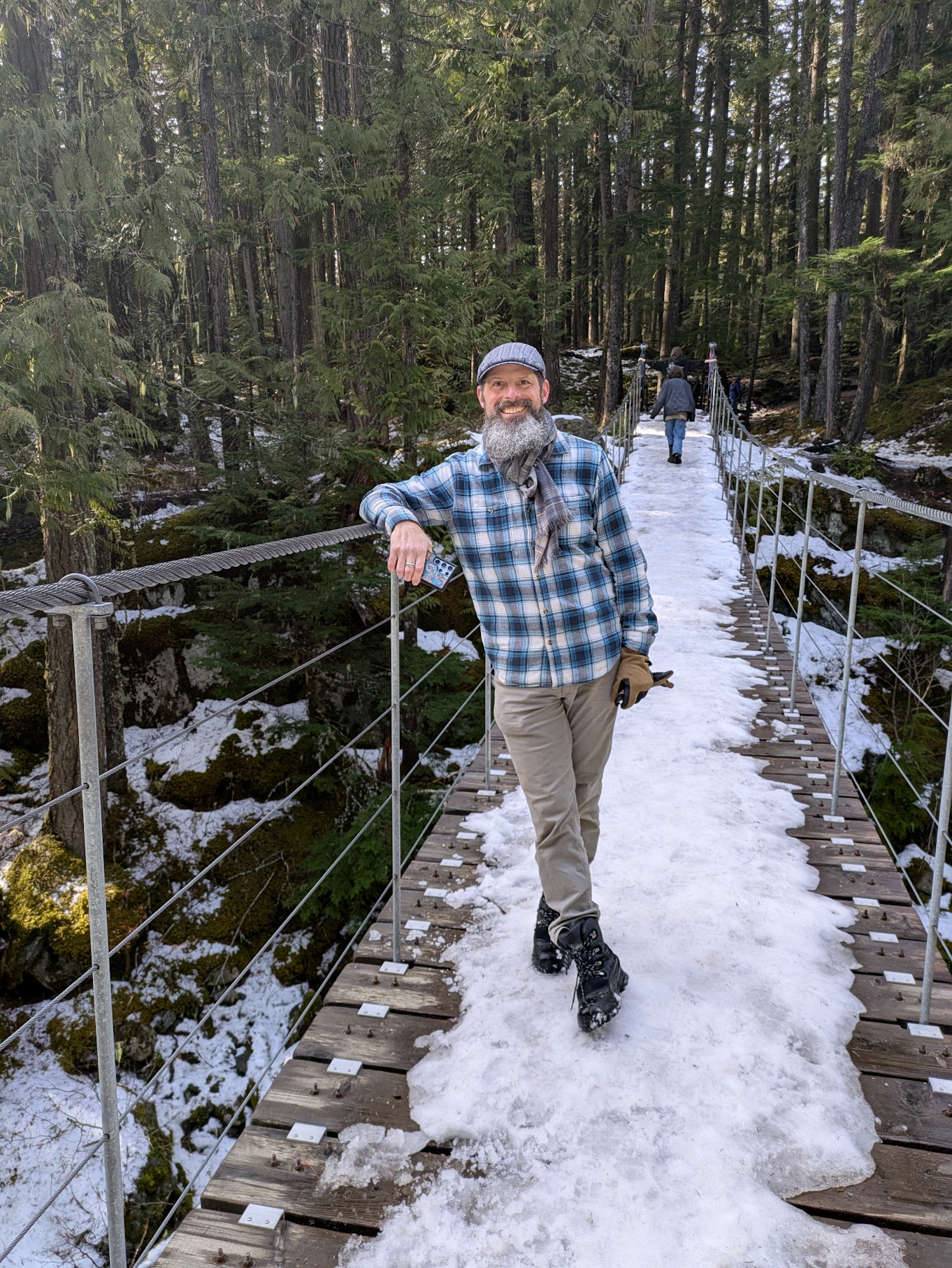 Jason on a snowy footbridge on a winter hike