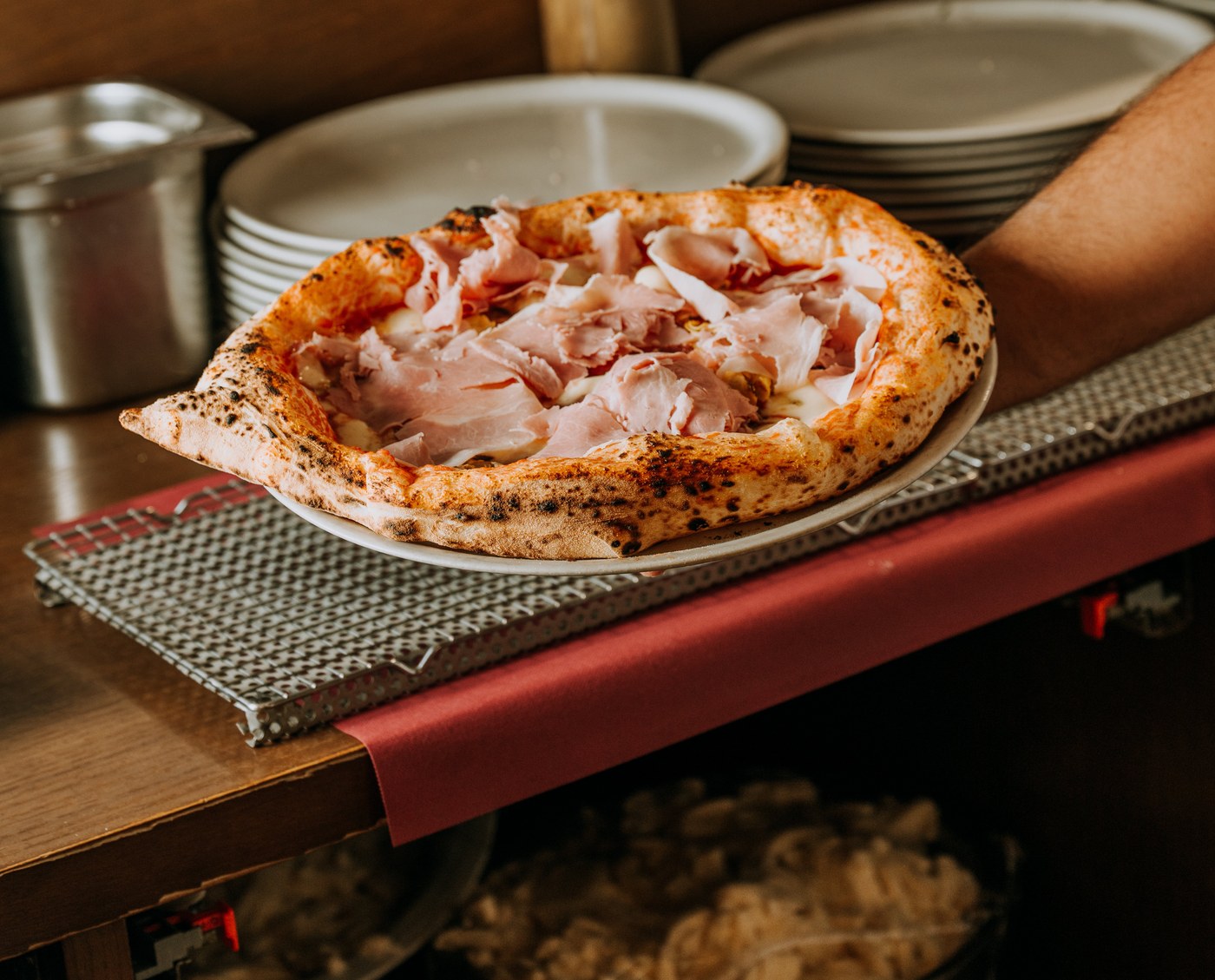 Detalle del cornicione hinchado y con manchas de leopardo de una pizza napolitana real en Spaccanapoli Barcelona