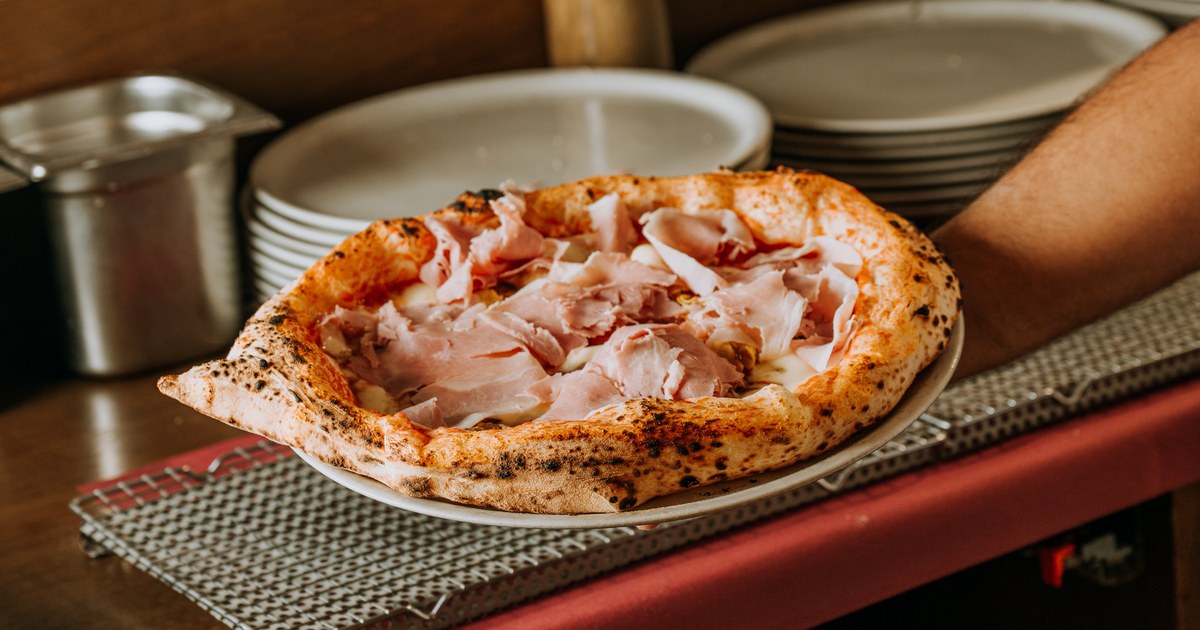 Pizza napolitana recién salida del horno de leña en Spaccanapoli Barcelona, con el cornicione hinchado y manchas de leopardo