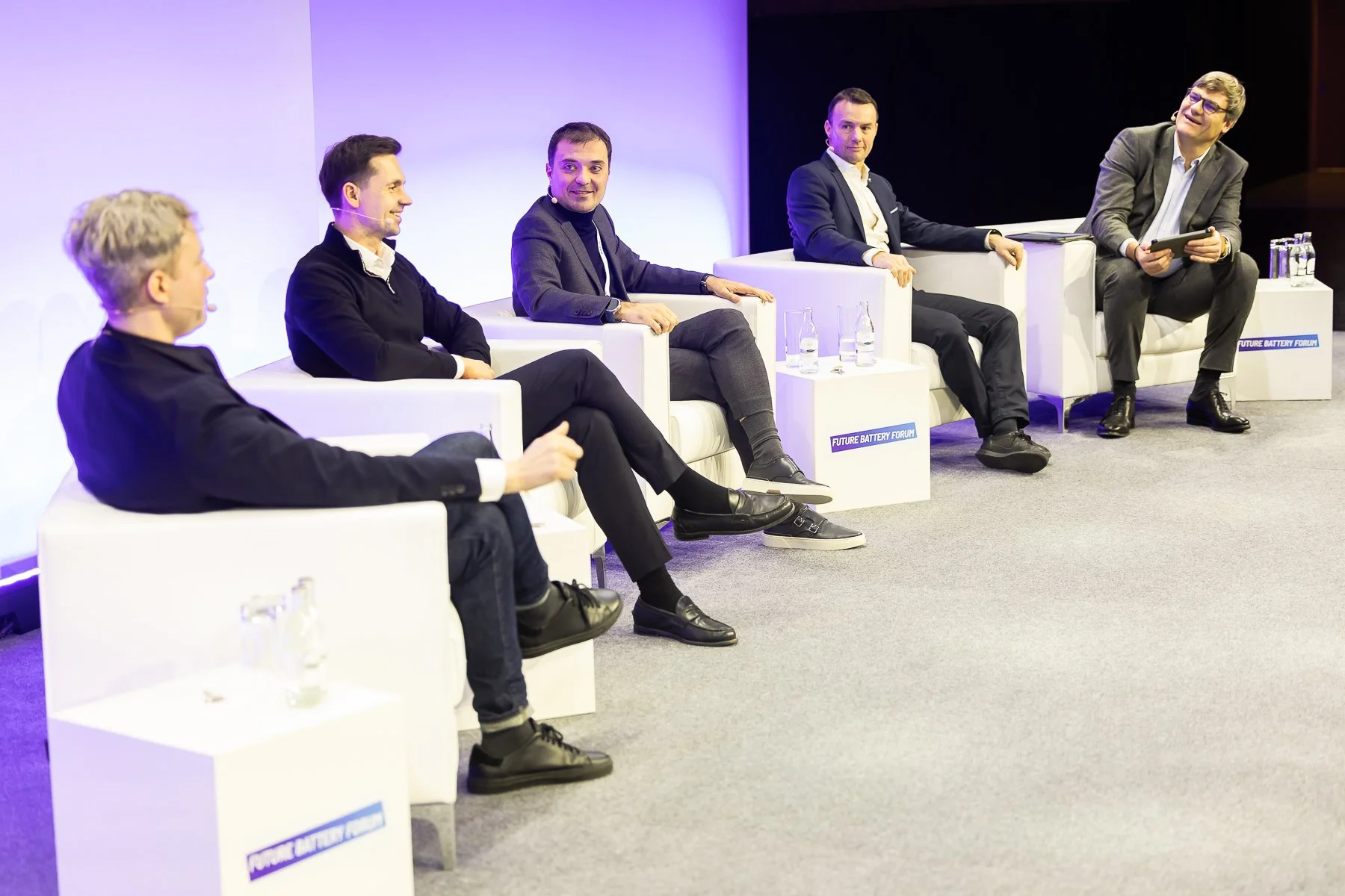 Panel discussion on stage at Future Battery Forum 2025, ECC Berlin, with event branding on the seat plinths.