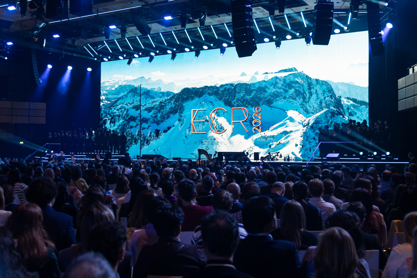 Eröffnungsfeier der ECR 2026 im Austria Center Vienna, eine blau beleuchtete Bühne mit großer Leinwand und vollem Saal