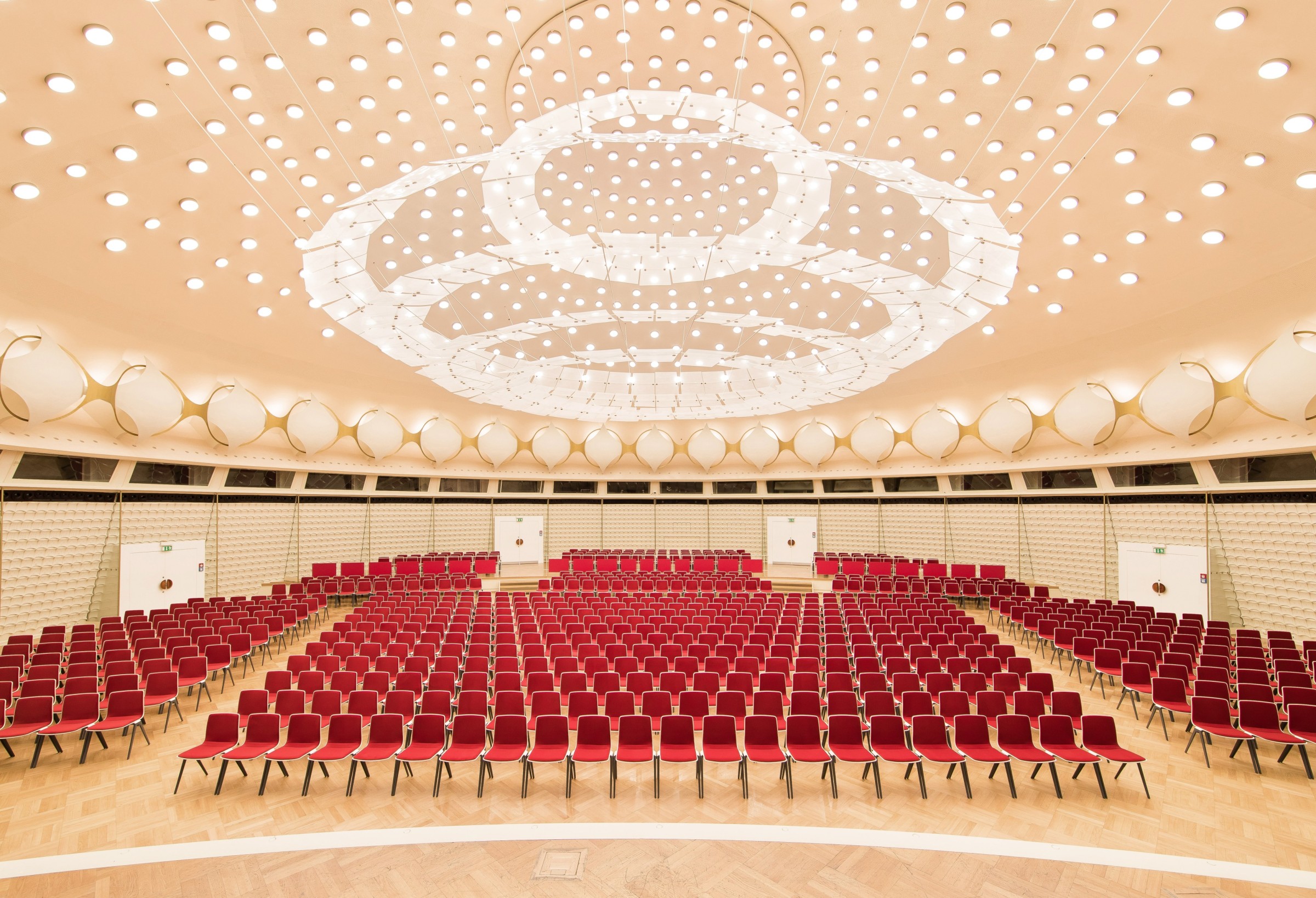 Domed hall at bcc Berlin Congress Center with rows of red conference seating