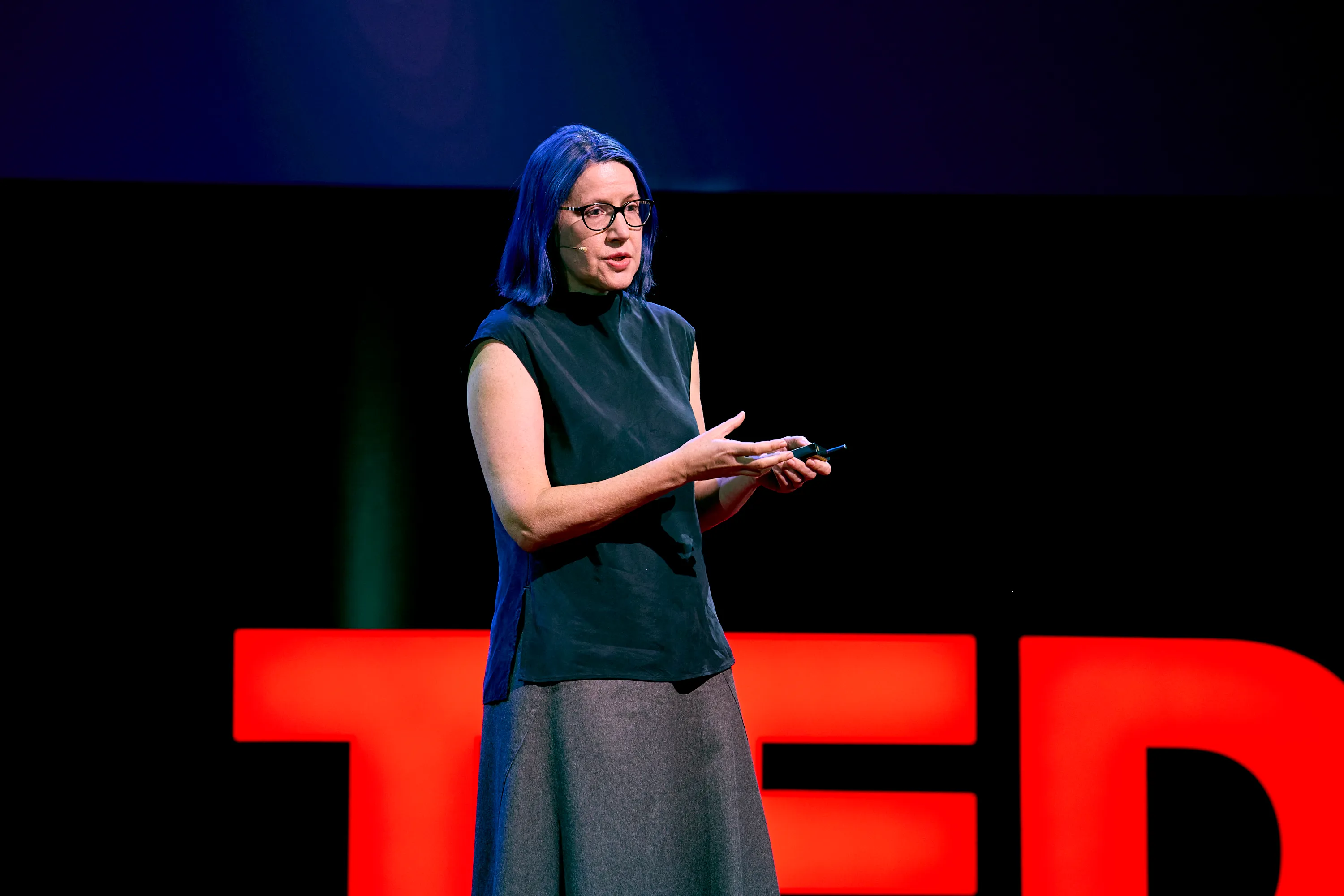 A speaker stands on the TED-branded main stage inside the Hofburg during TEDAI Vienna