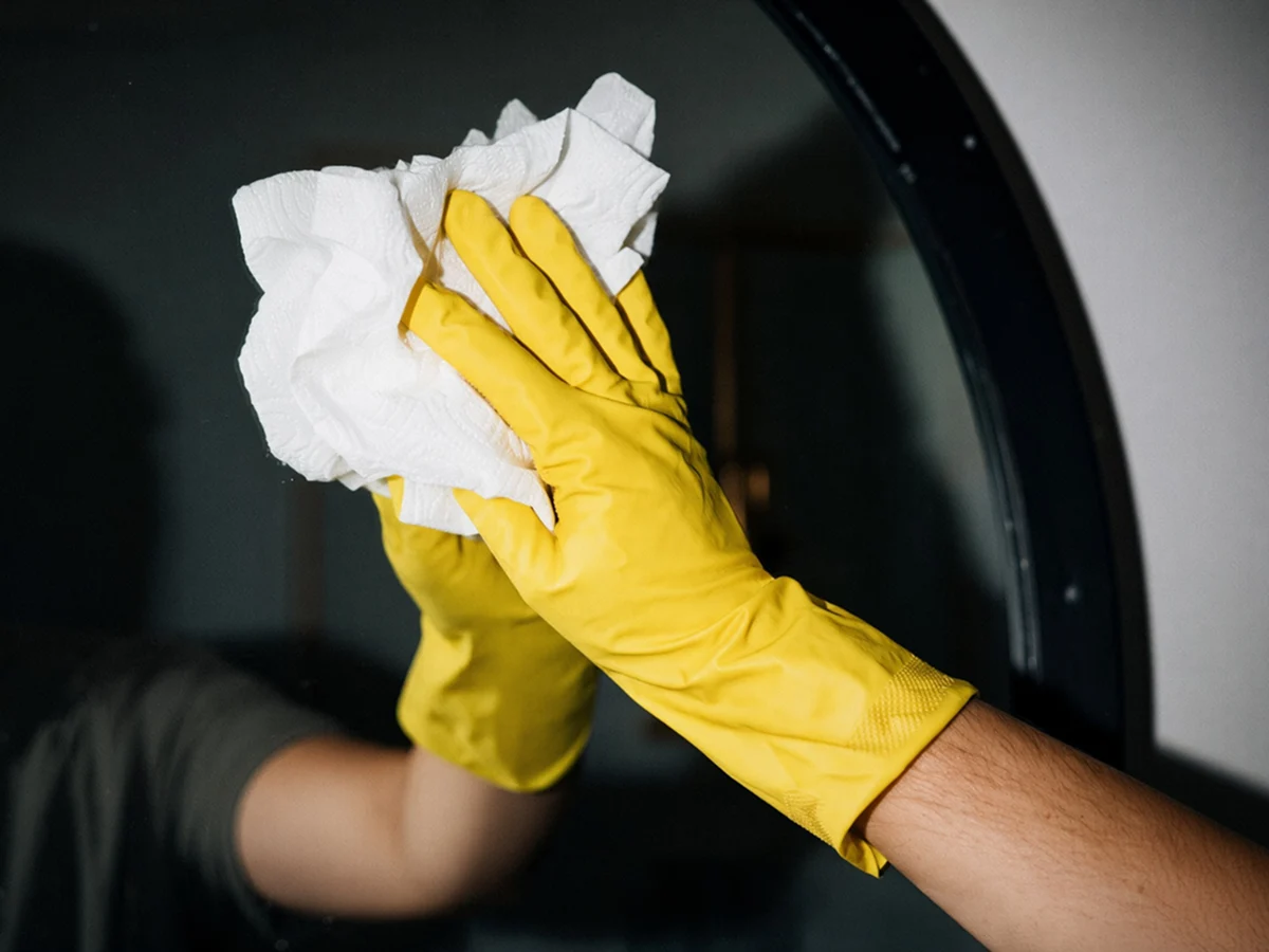 House cleaner wiping a mirror