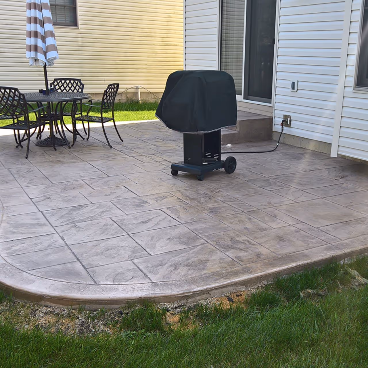 Stamped concrete patio installation with decorative finish for a custom outdoor living space by Landa Construction Services