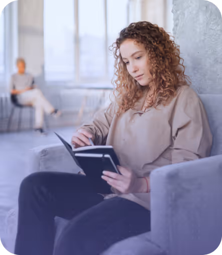 Photo of a person sitting in a chair and reading a book