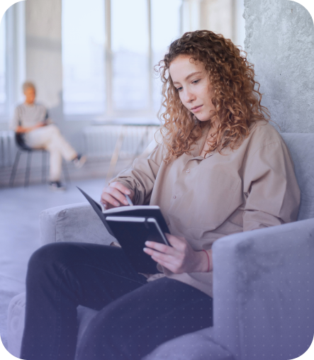 Photo of a person sitting in a chair and reading a book