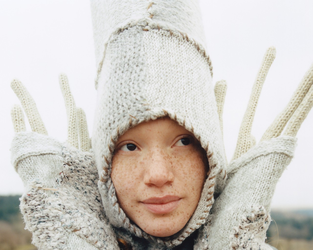 A young woman wears a white costume.
