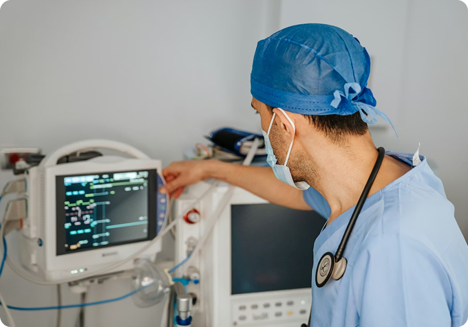 Surgeon monitoring medical equipment, representing the firm's focus on clinical operations and provider practices.