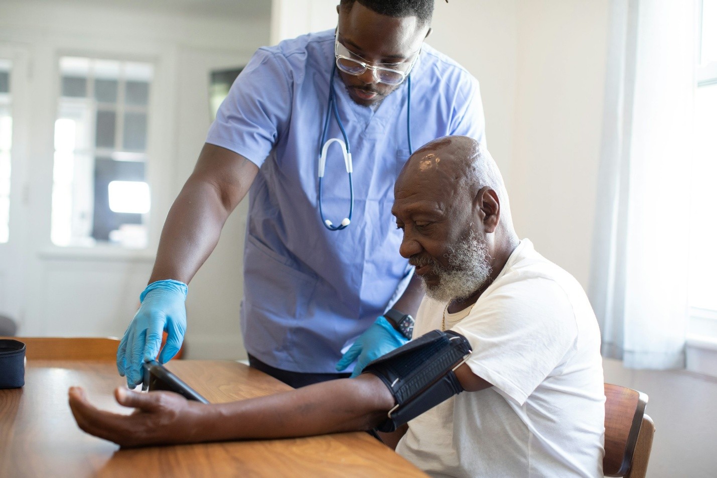 Healthcare professional monitoring a patient's vitals, representing the operational delivery of primary and long-term care services.