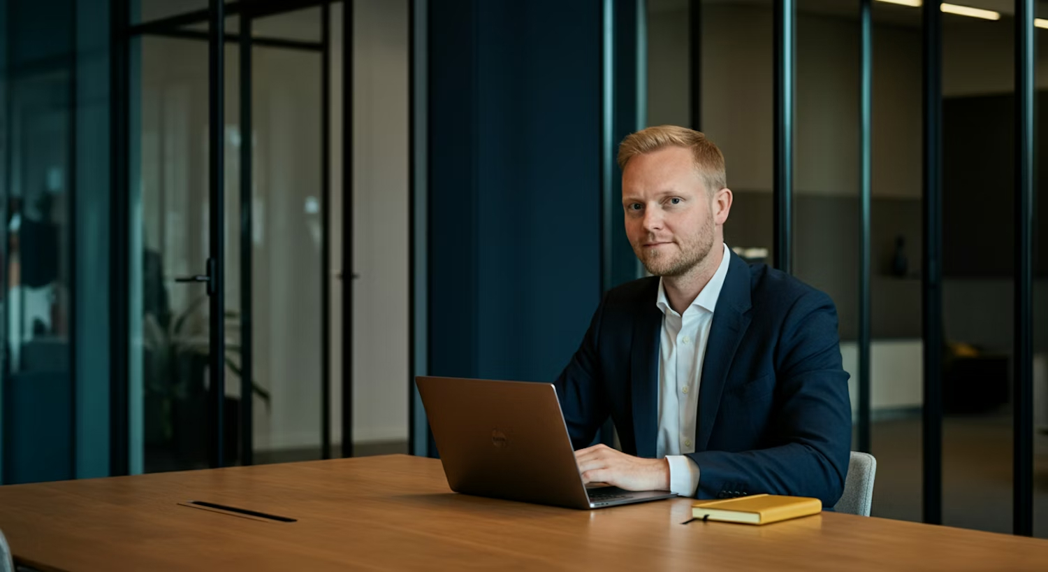 Professional in a suit seated at a desk with a laptop, representing the strategic evaluation and diligence of healthcare capital partnerships.