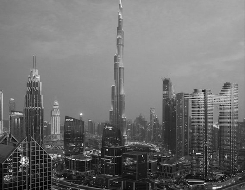 City skyline featuring the Burj Khalifa and surrounding skyscrapers at dusk.