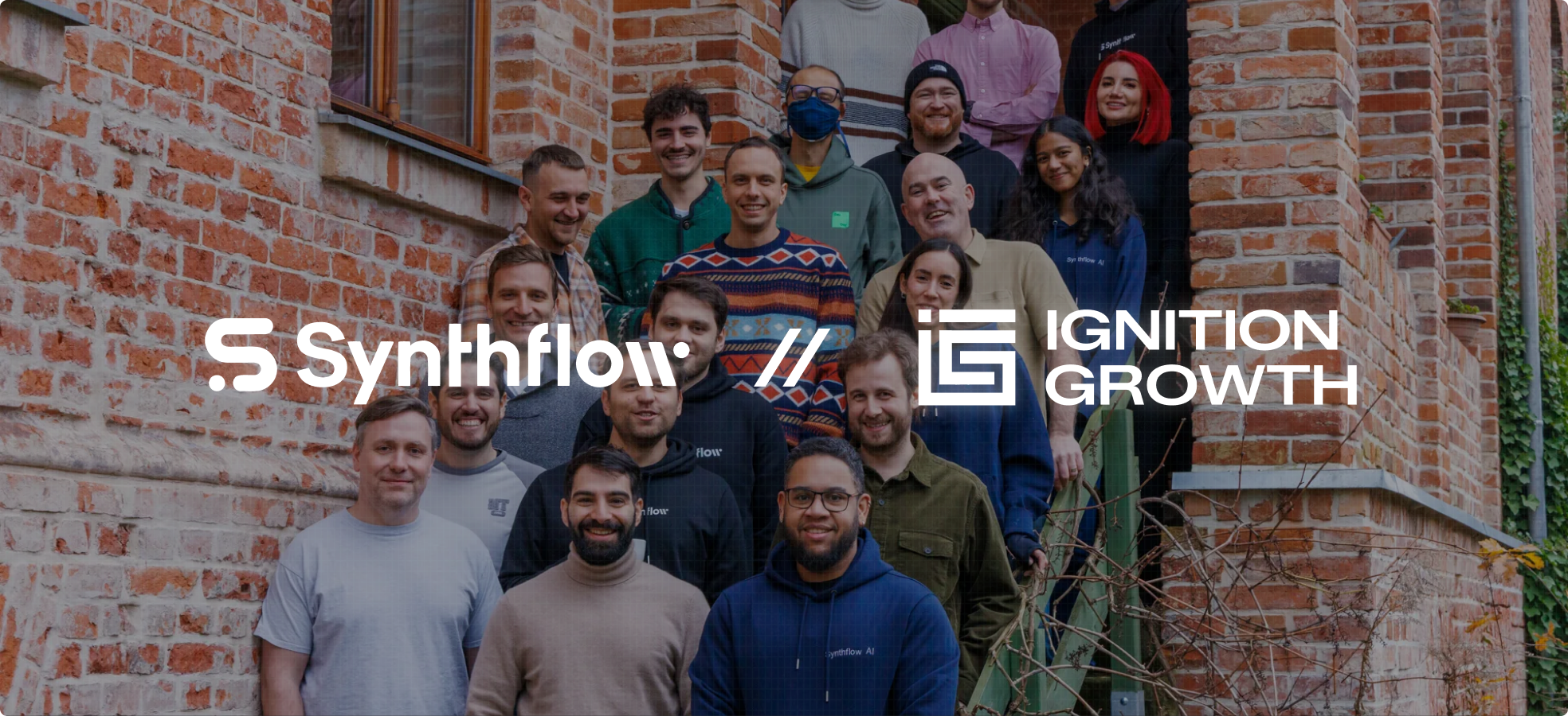 Group photo of diverse Synthflow team members standing on outdoor steps beside a brick building with Synthflow and Ignition Growth logos overlayed.