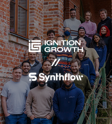 Group of 14 people standing and smiling on outdoor stairs next to a brick building, with Ignition Growth and Synthflow logos overlayed.
