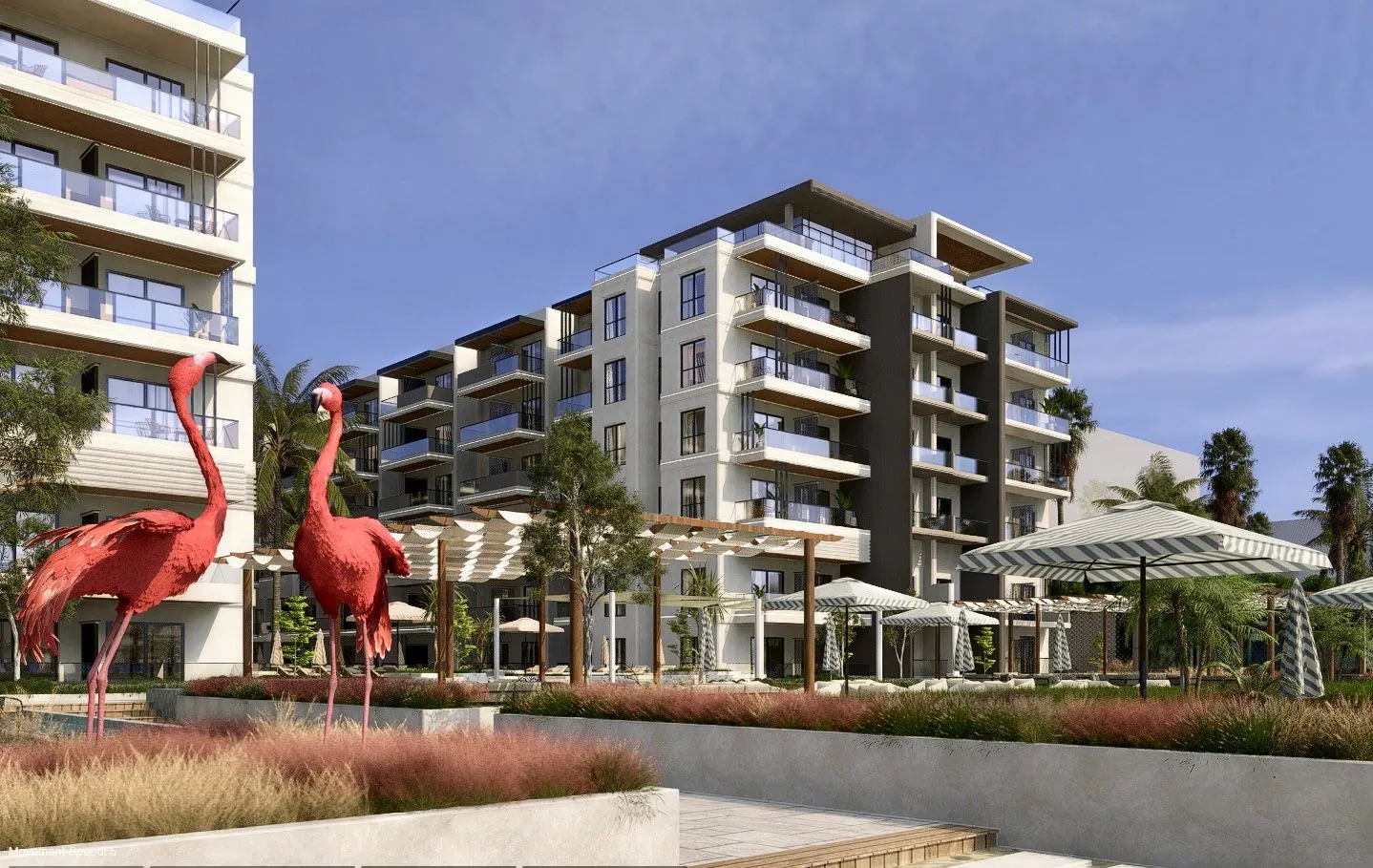 Modern apartment complex with balconies, outdoor seating areas under striped umbrellas, and two large red flamingo statues in the foreground.