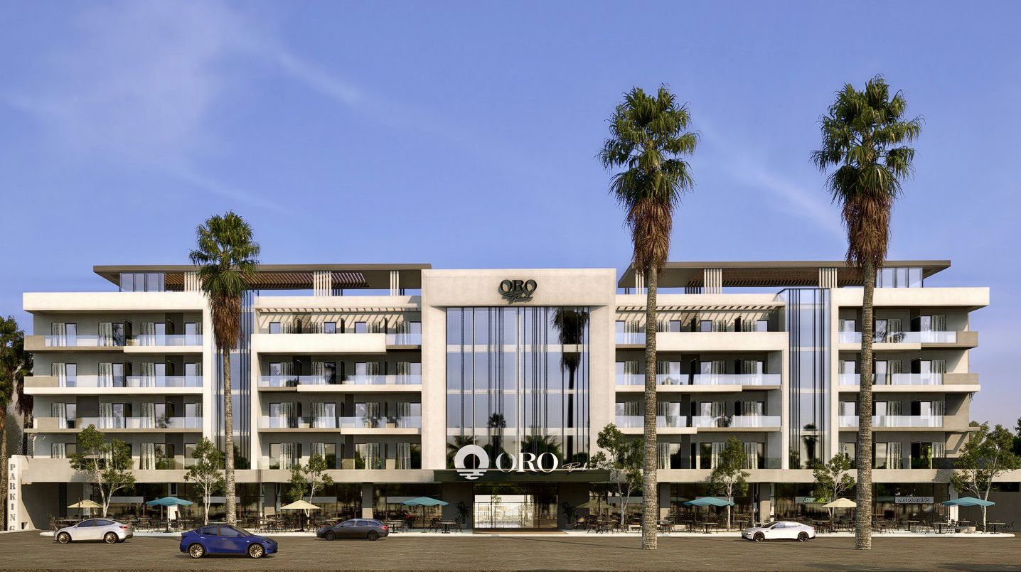 Modern five-story building named ORO with large glass windows, balconies, palm trees, and parked cars in front.