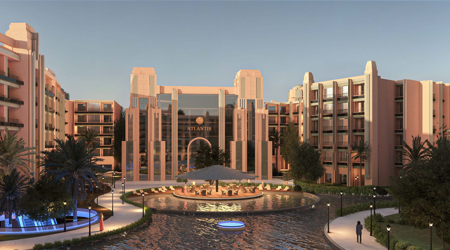 Modern luxury resort entrance with pinkish buildings, a water feature, palm trees, and outdoor seating under a large umbrella.