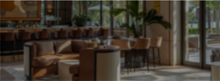Cozy restaurant seating with brown chairs, tables, and large windows letting in natural light.