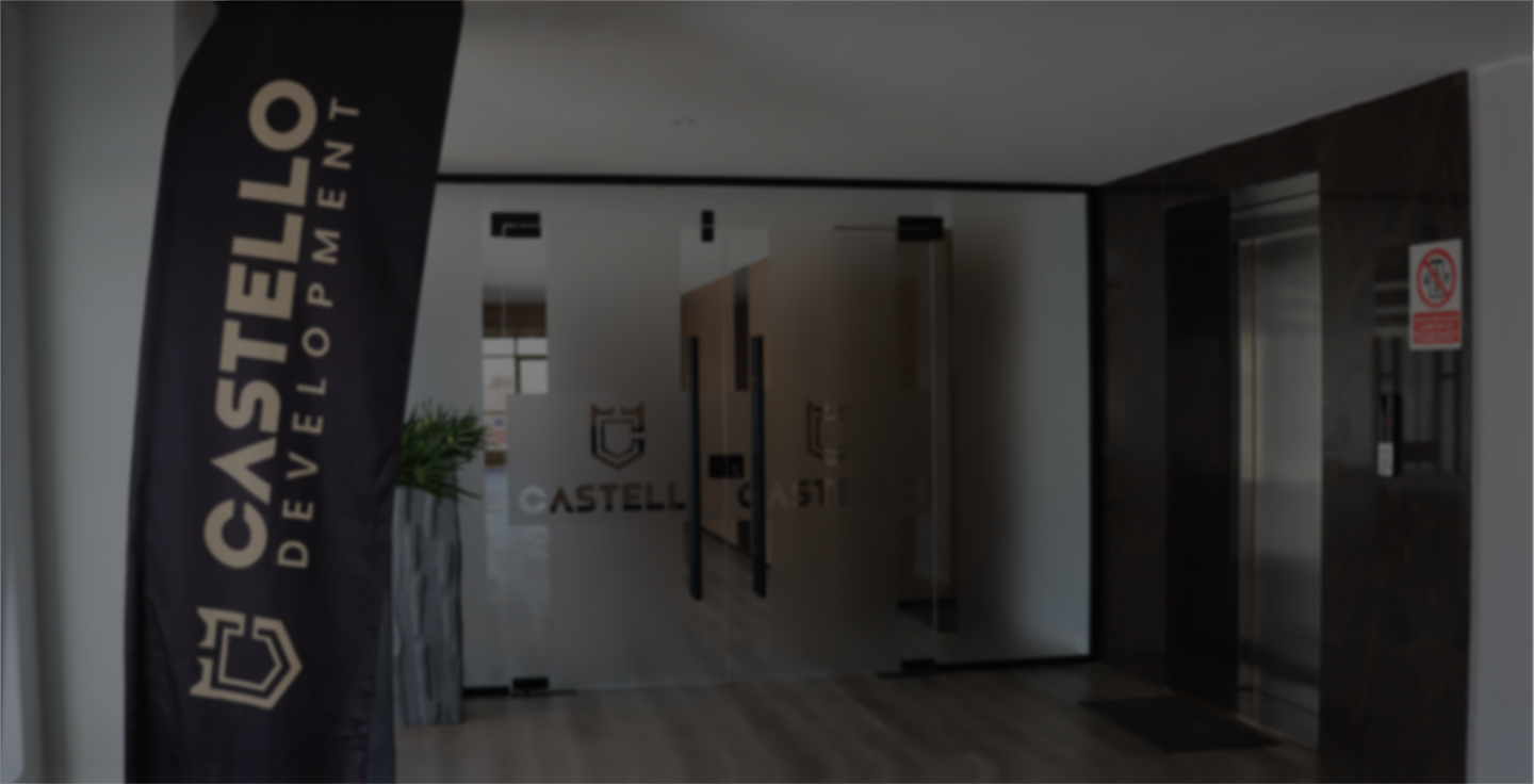 Office entrance with frosted glass doors labeled CASTELLO and a black vertical banner with CASTELLO Development text.
