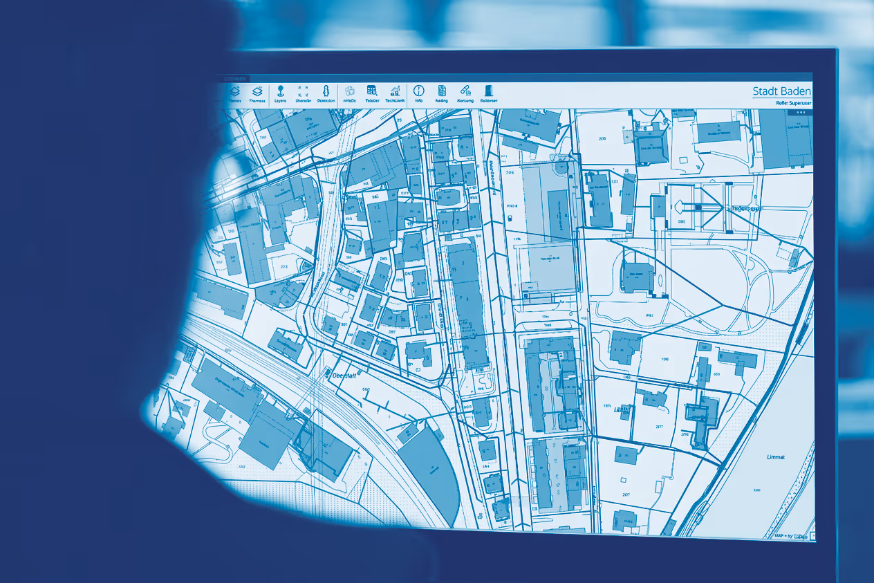 Person betrachtet digitalen Stadtplan von Baden auf einem Bildschirm mit Straßen, Gebäuden und Fluss Limmat.