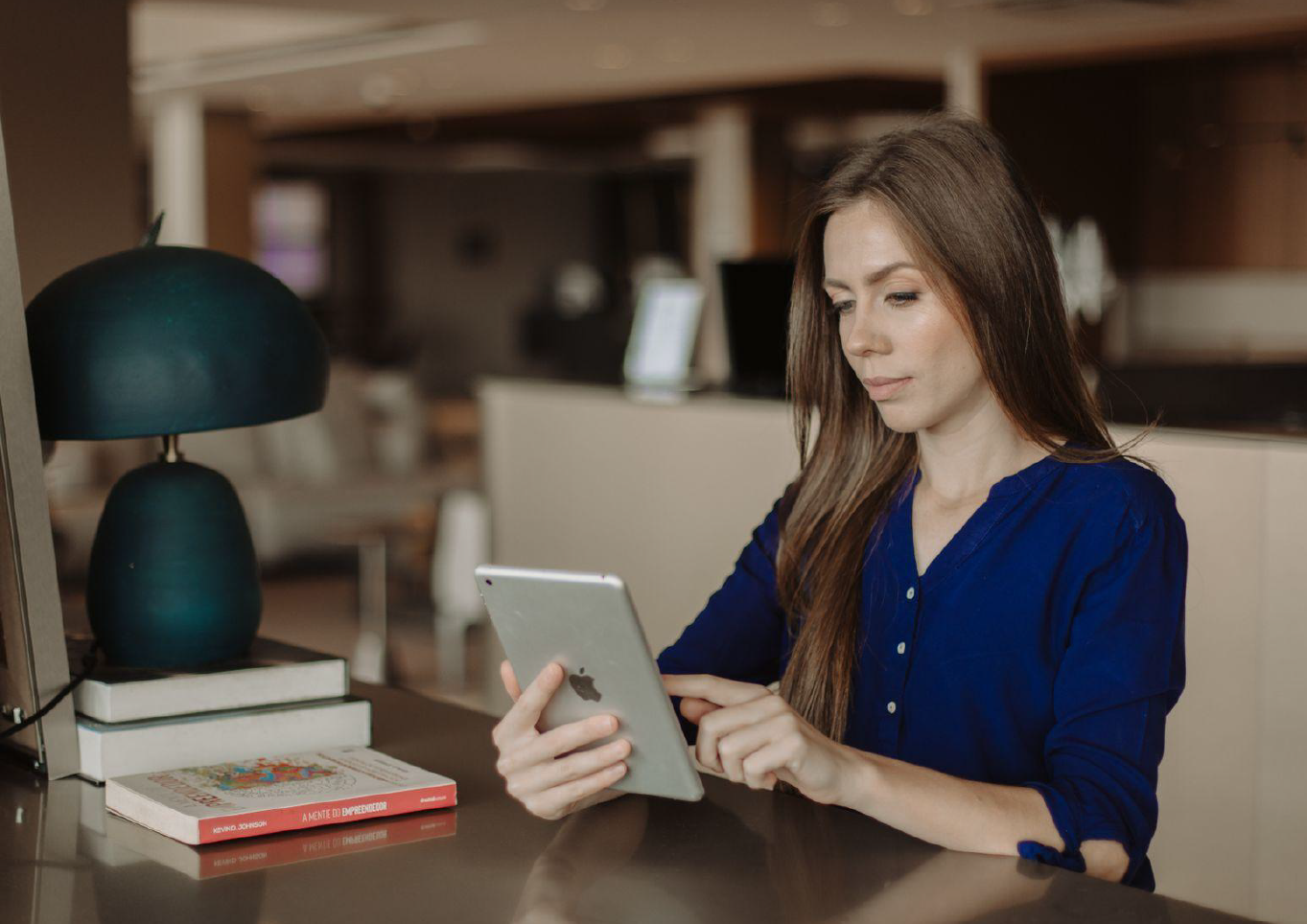 Woman in library looking at iPad.