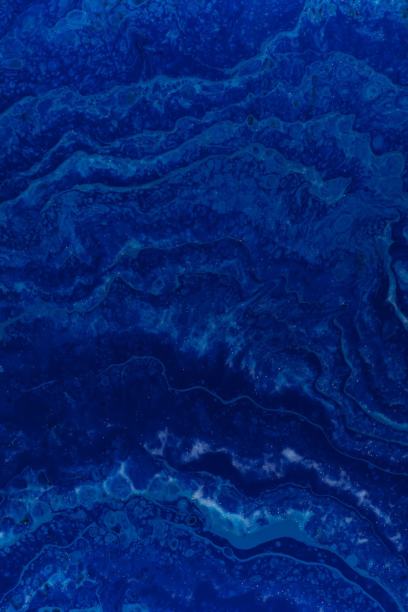 Close-up of deep blue ocean water with swirling patterns and light reflections.