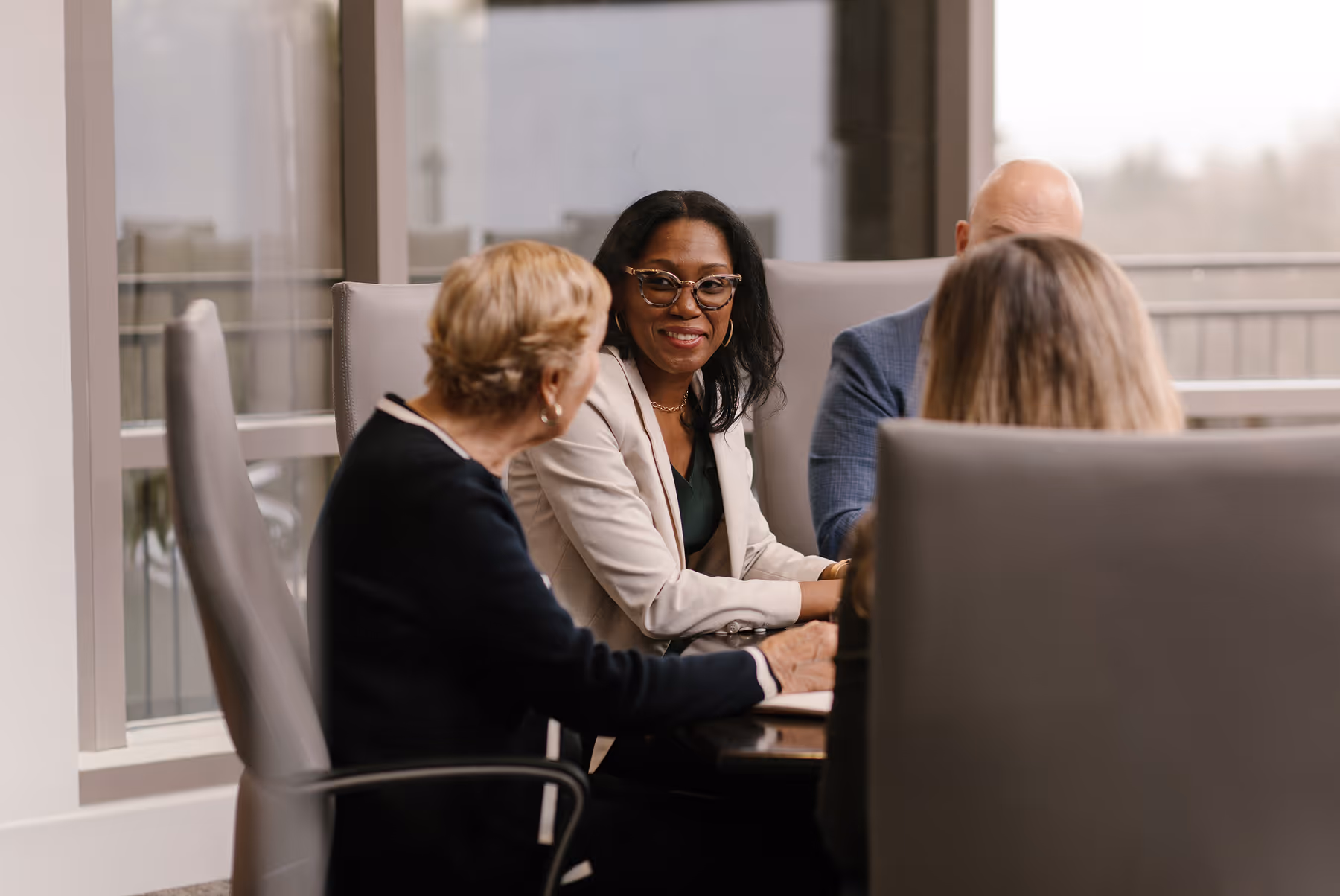 A group of professionals having a business meeting around a conference table in a modern office.
