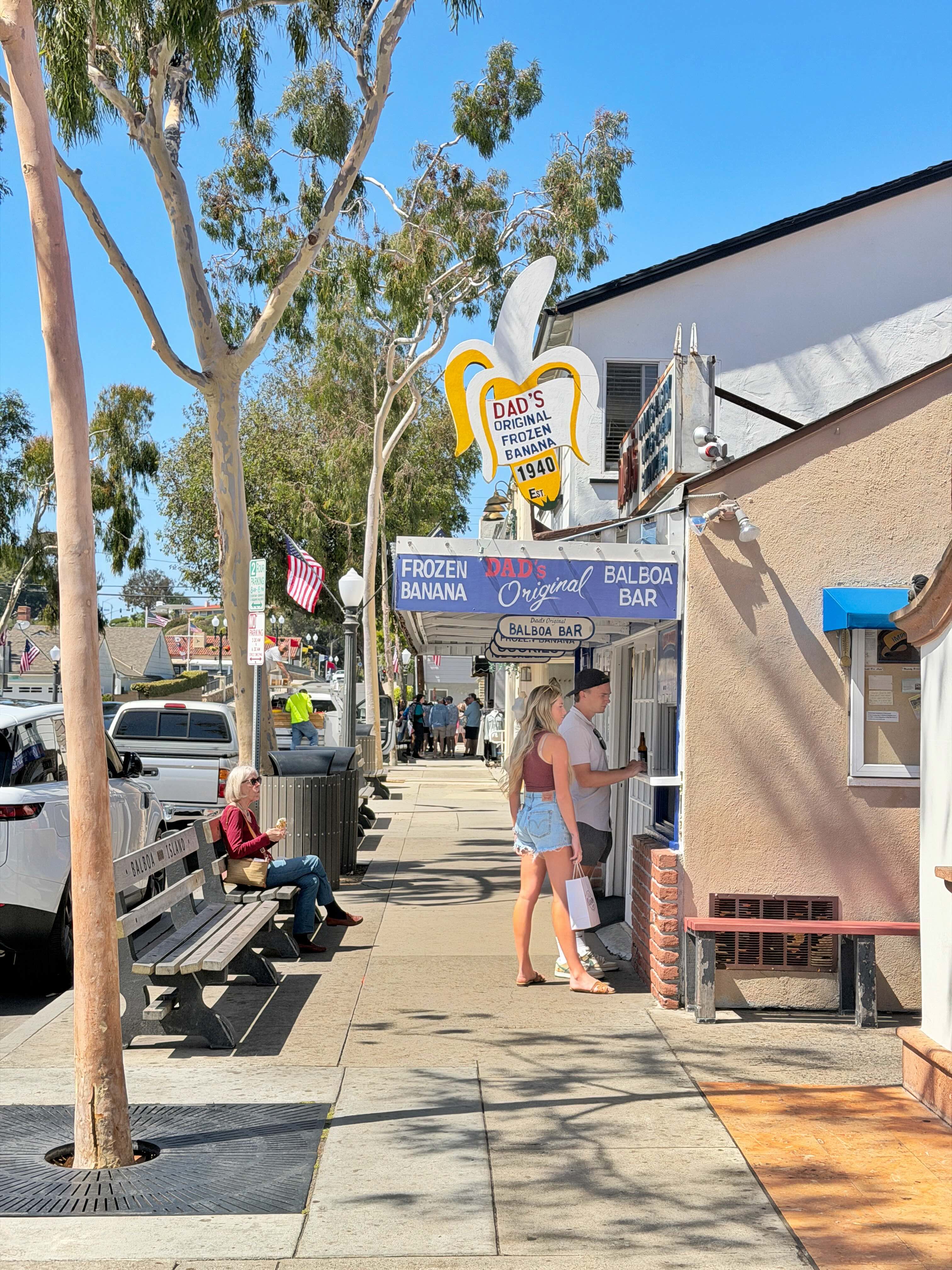Dad's Original Frozen Banana on Balboa Island — yellow and white storefront sign on Marine Avenue with eucalyptus trees overhead
