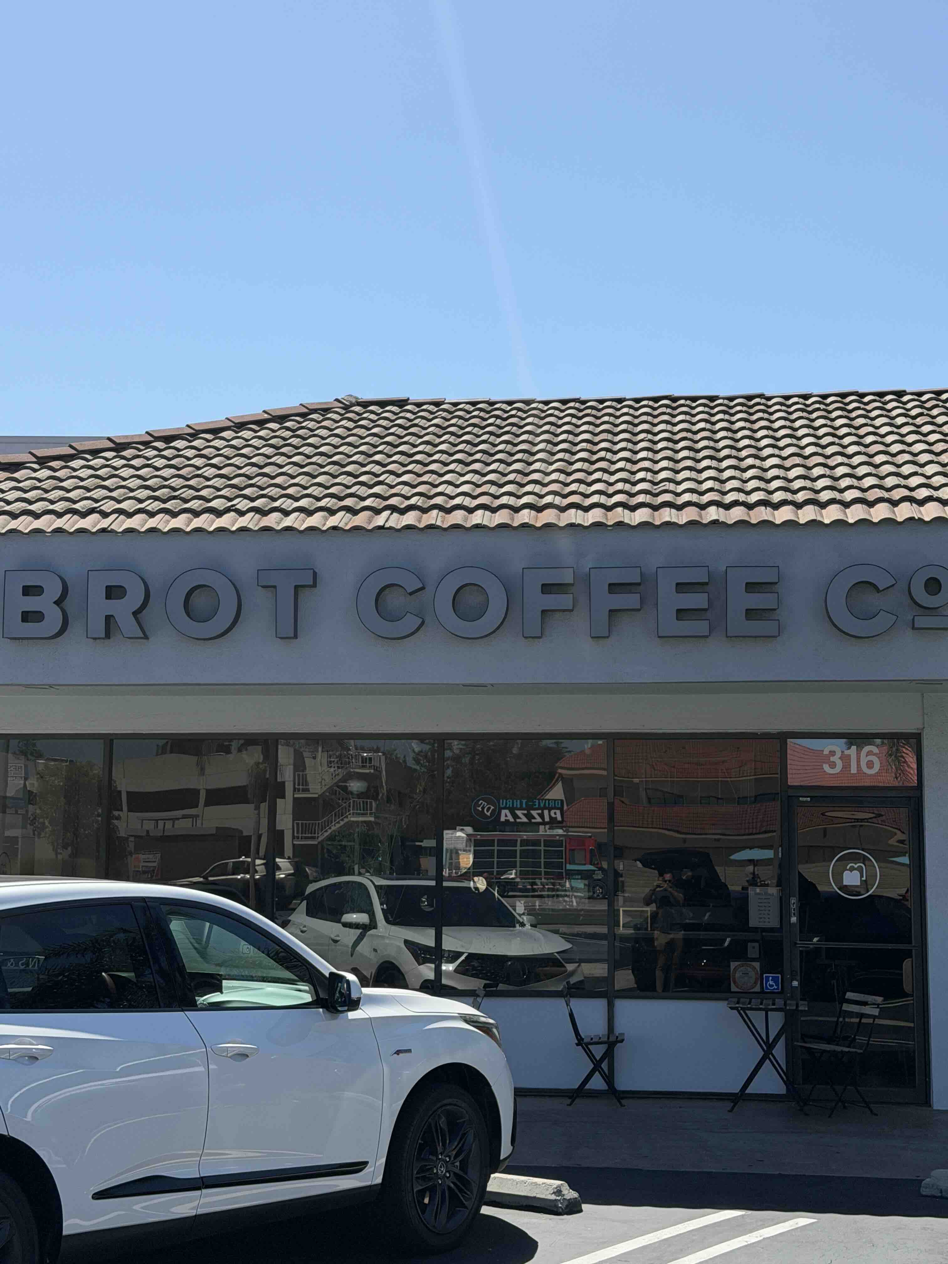 Brot Coffee Co storefront at 316 S. Main Street in Orange, with channel-letter signage beneath a Spanish tile roof.