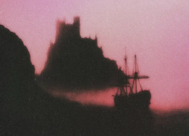Silhouette of a ship near a rocky coastline with a castle atop a hill at sunset.