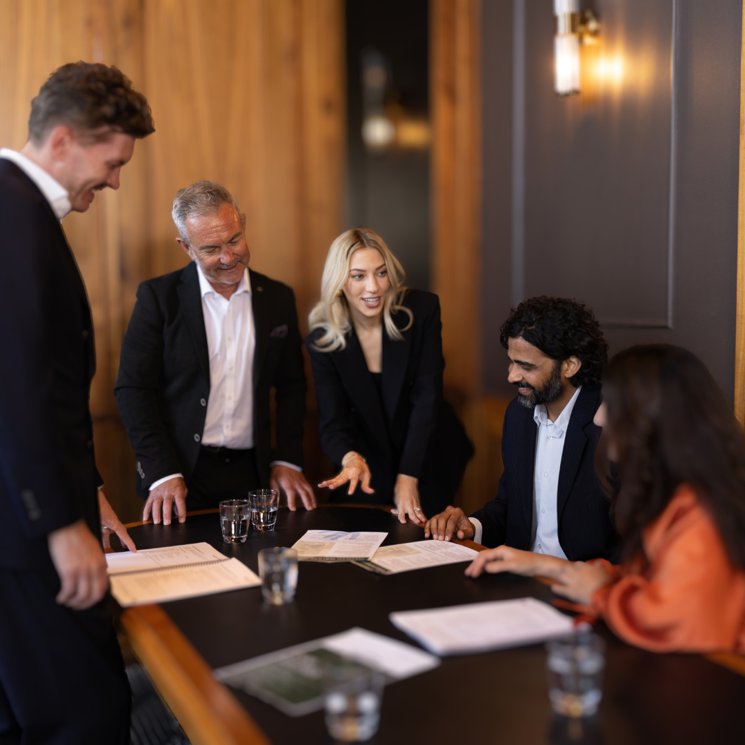 Winston Gray team presenting proposals to clients around a luxury boardroom table