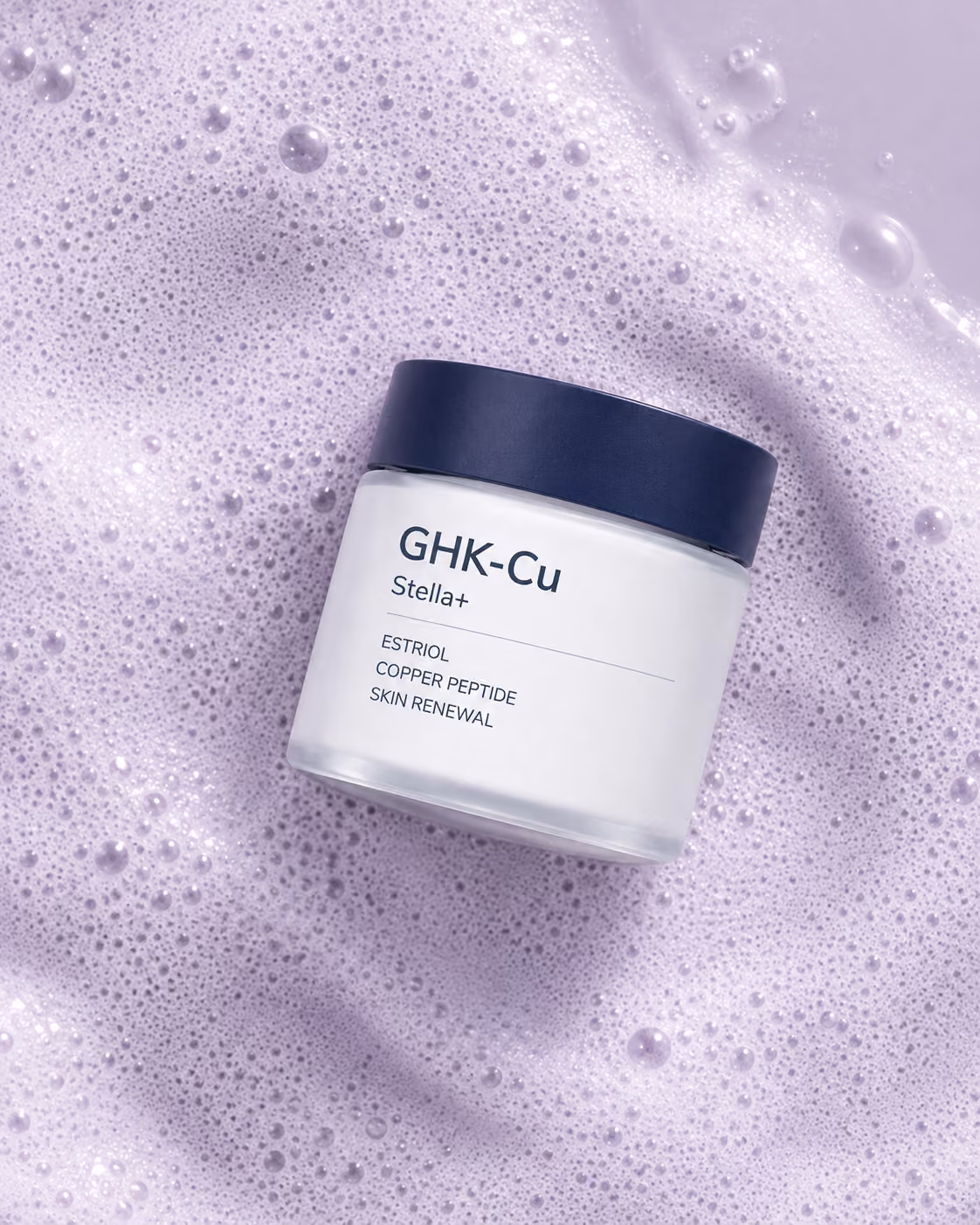 GHK-Cu Stella+ cream jar with a navy lid resting in soft lilac foam