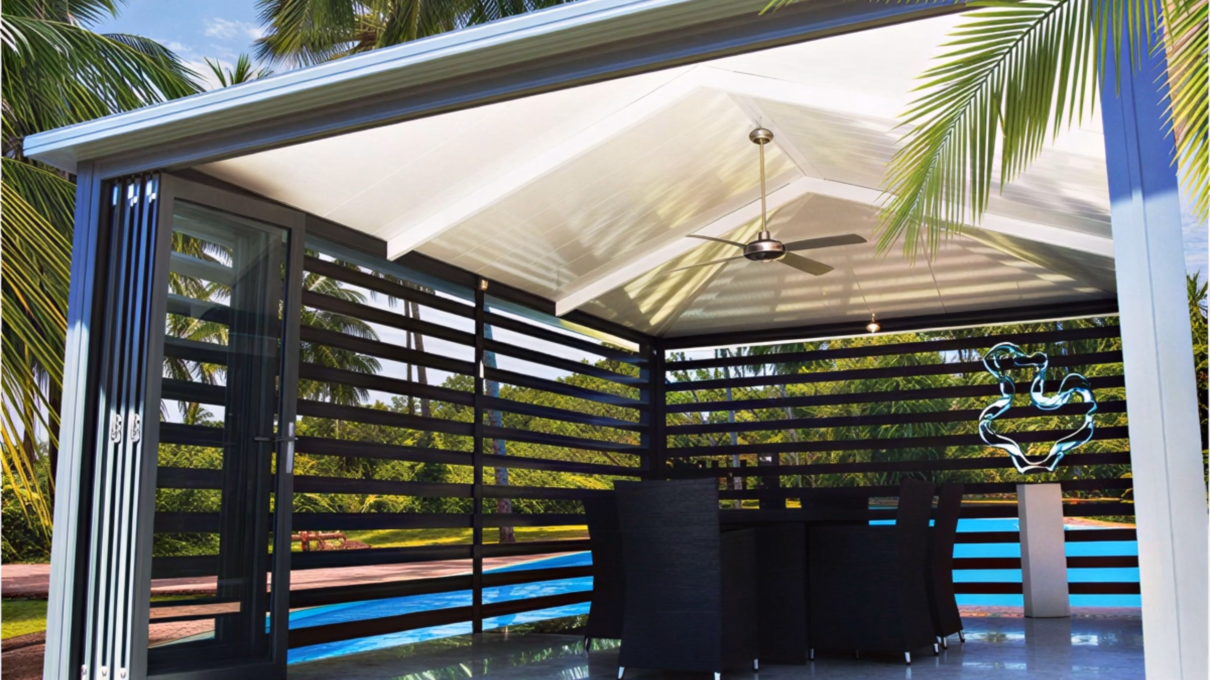 Modern outdoor patio with insulated gable roof, ceiling fan, black slatted walls, glass door, and dining set.