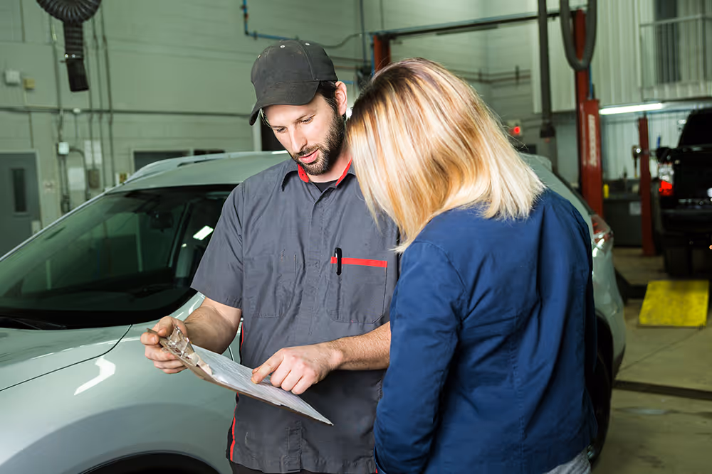 Mechanic explaining a repair quote to a customer at the workshop