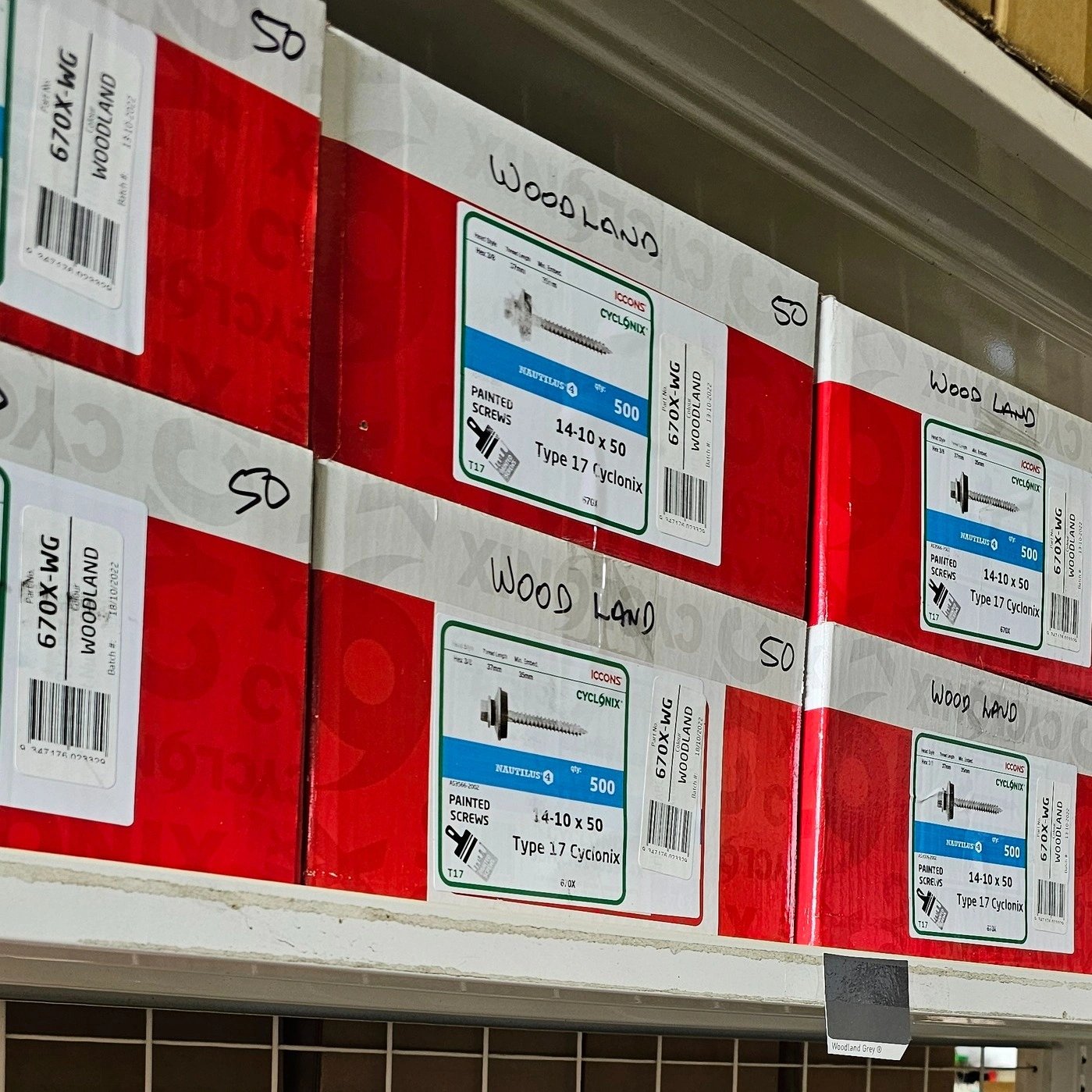 Shelves with red and white boxes labeled 'Woodland' containing Type 17 Cyclonix painted screws, size 14-10 x 50, 500 pieces per box.