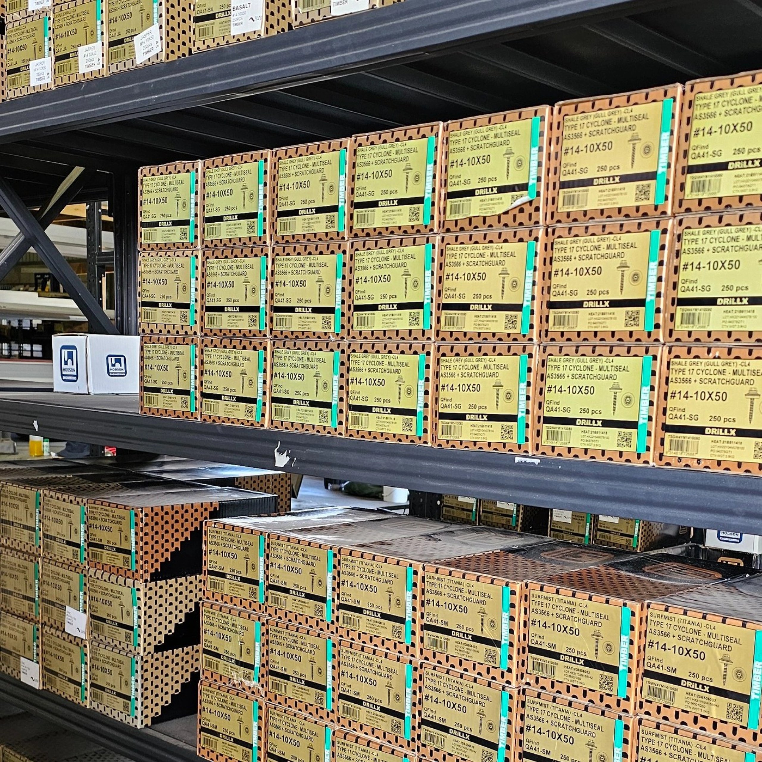 Warehouse shelves stacked with boxes of #14-10X50 screws labeled with product details and quantities.