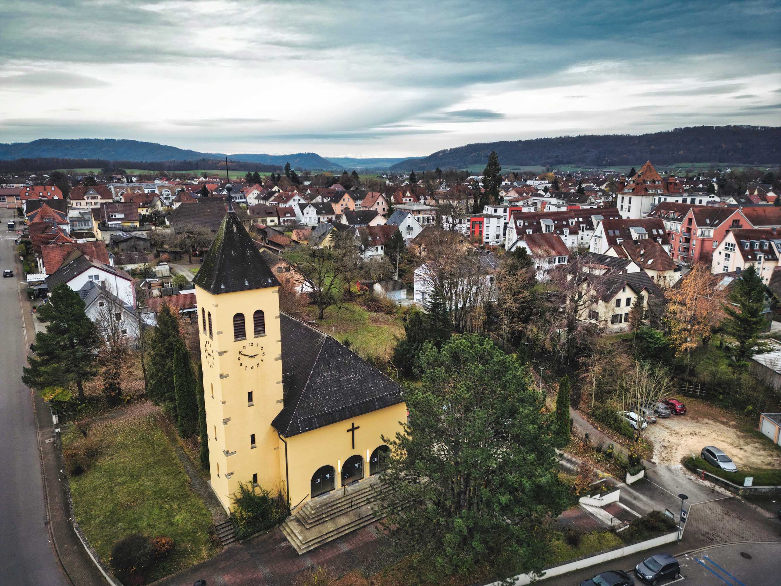 Drohnenbild einer Kirche mit einer Stadt im Hintergrund